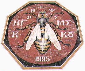 The golden bee of Kykkos, depicted in the marble floor mosaic of the Kykkos Museum, dated 1995, surrounded by the abbreviated inscription Ηγρ Νκφρ Μς Κκο.