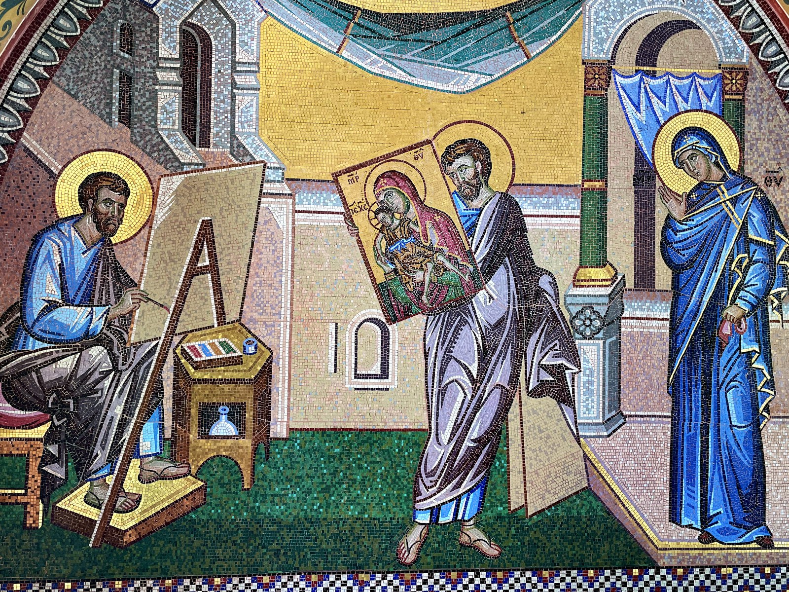 Mosaic at Kykkos Monastery: the Evangelist Luke seated at his easel paints the Holy Icon, while a bishop carries the painted panel toward the Theotokos who stands in her blue maphorion at the right.